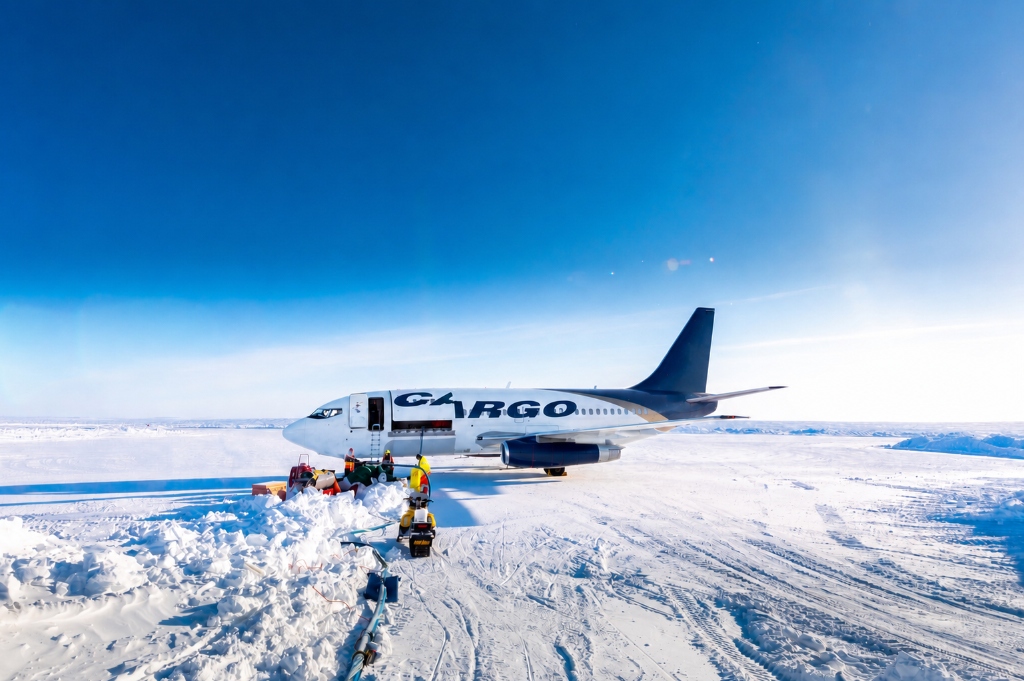 A heavy cargo aircraft unloading on an ice runway in the Arctic