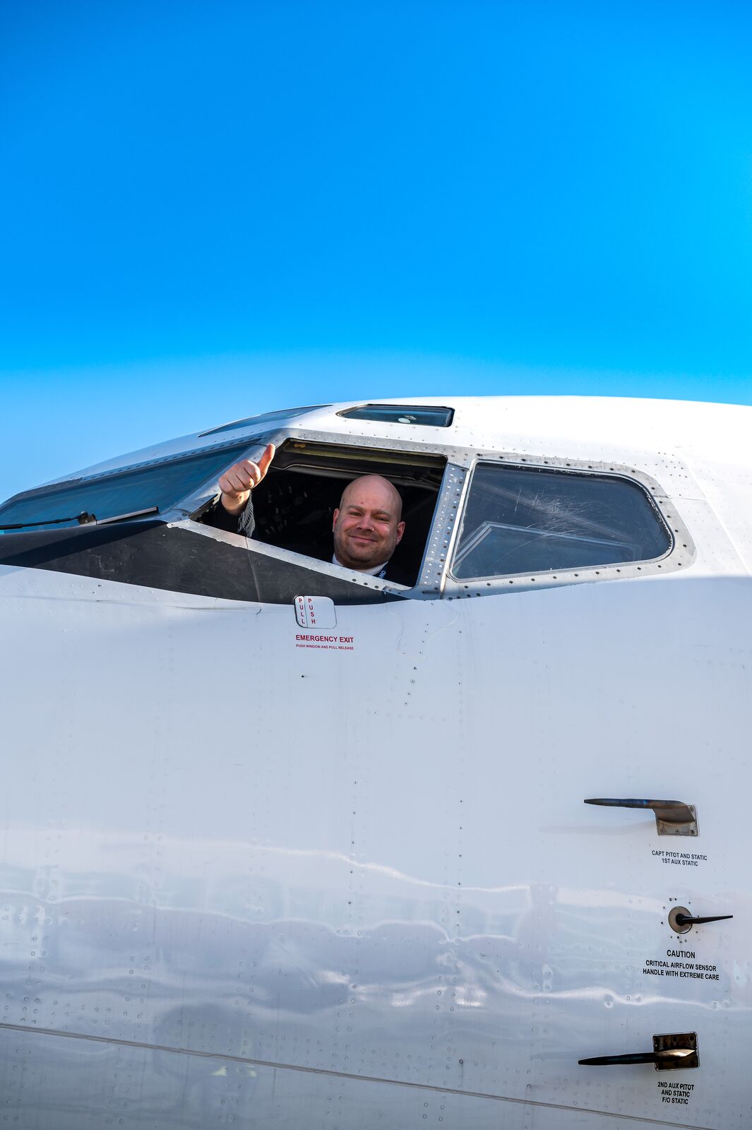 Captain giving a thumbs-up from the cockpit window