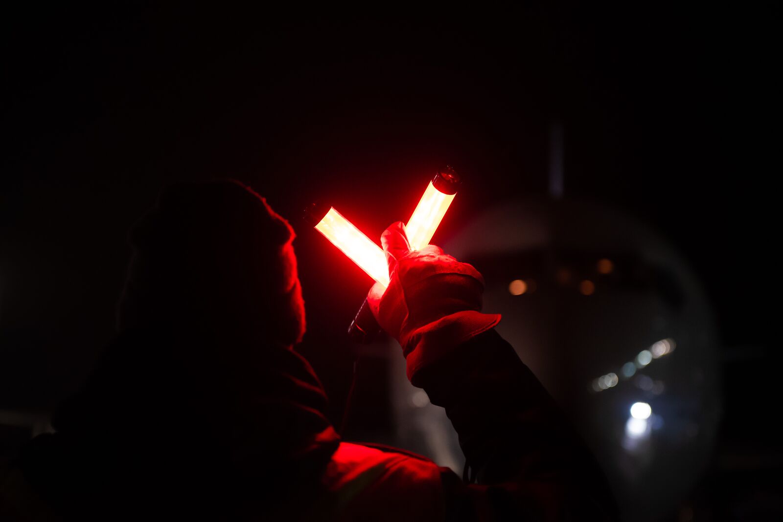 Ground crew with a marshalling wand at night